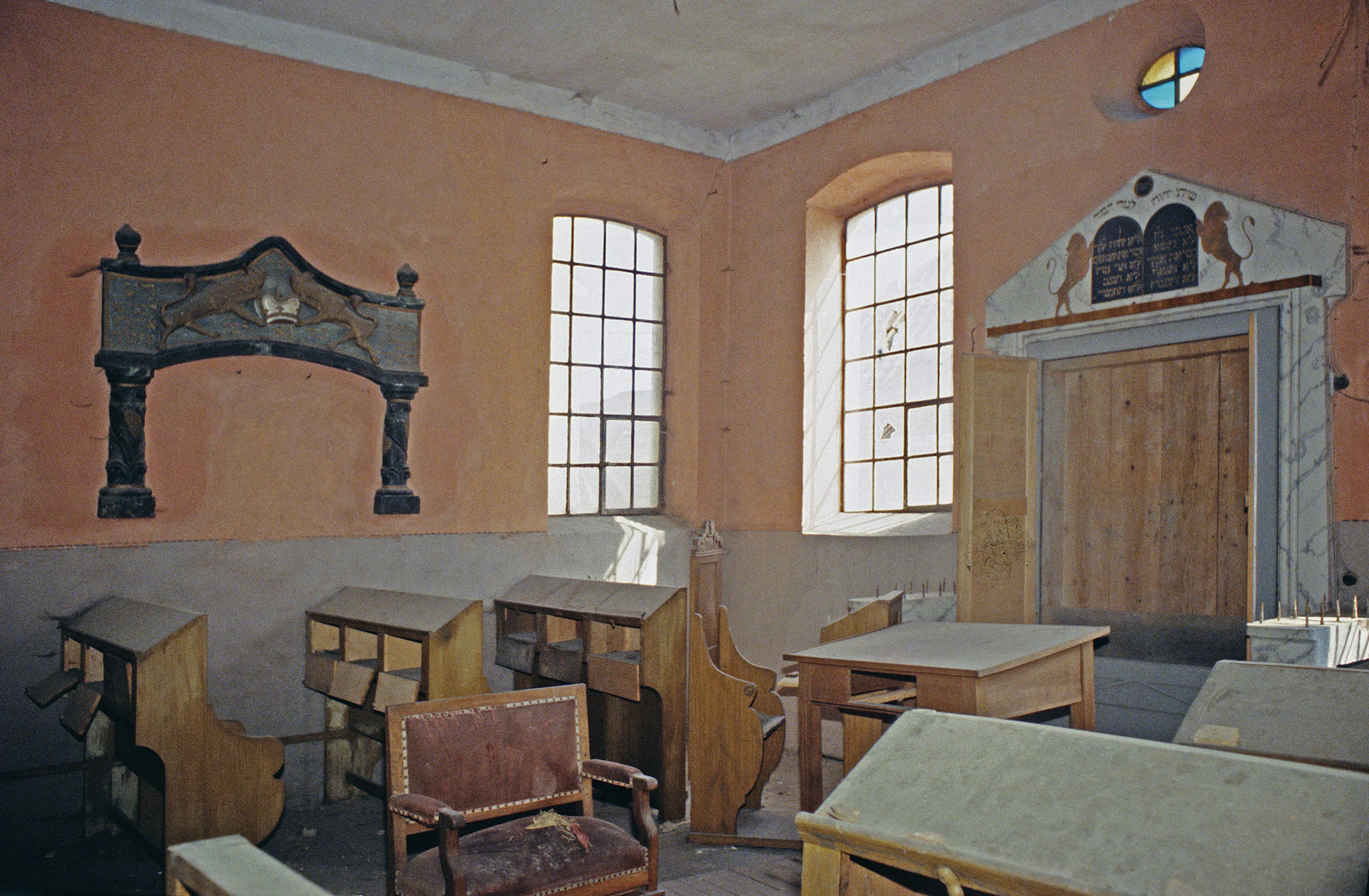 A torah ark carved with lions and straight-backed benches with scroll-work armrests, 1995