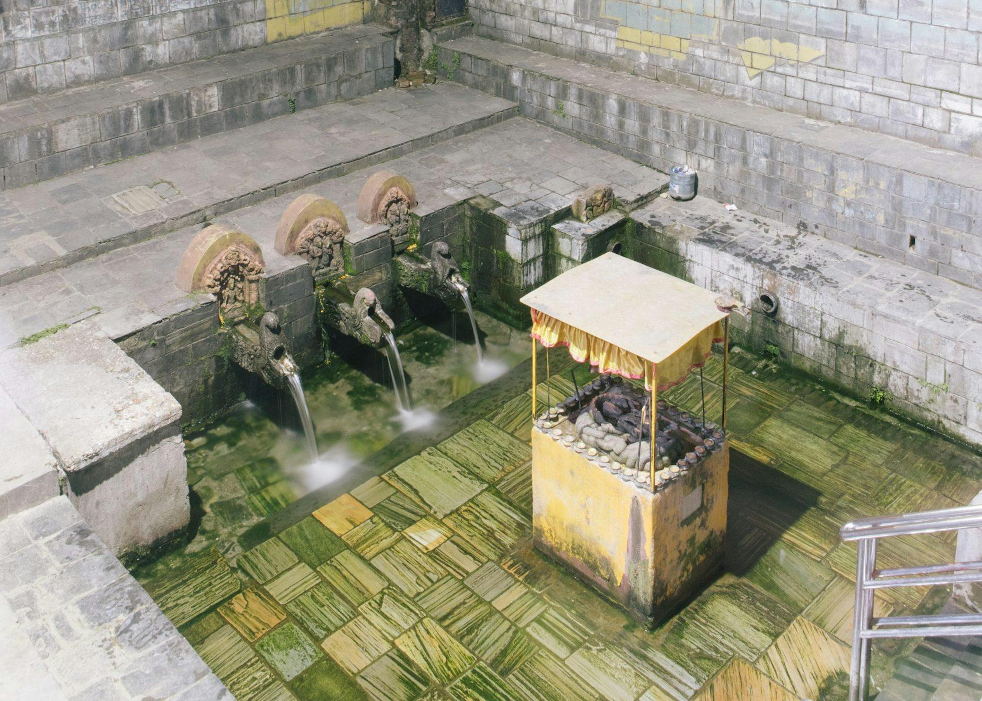 A hiti with fountains is surrounded by gates at its opening.