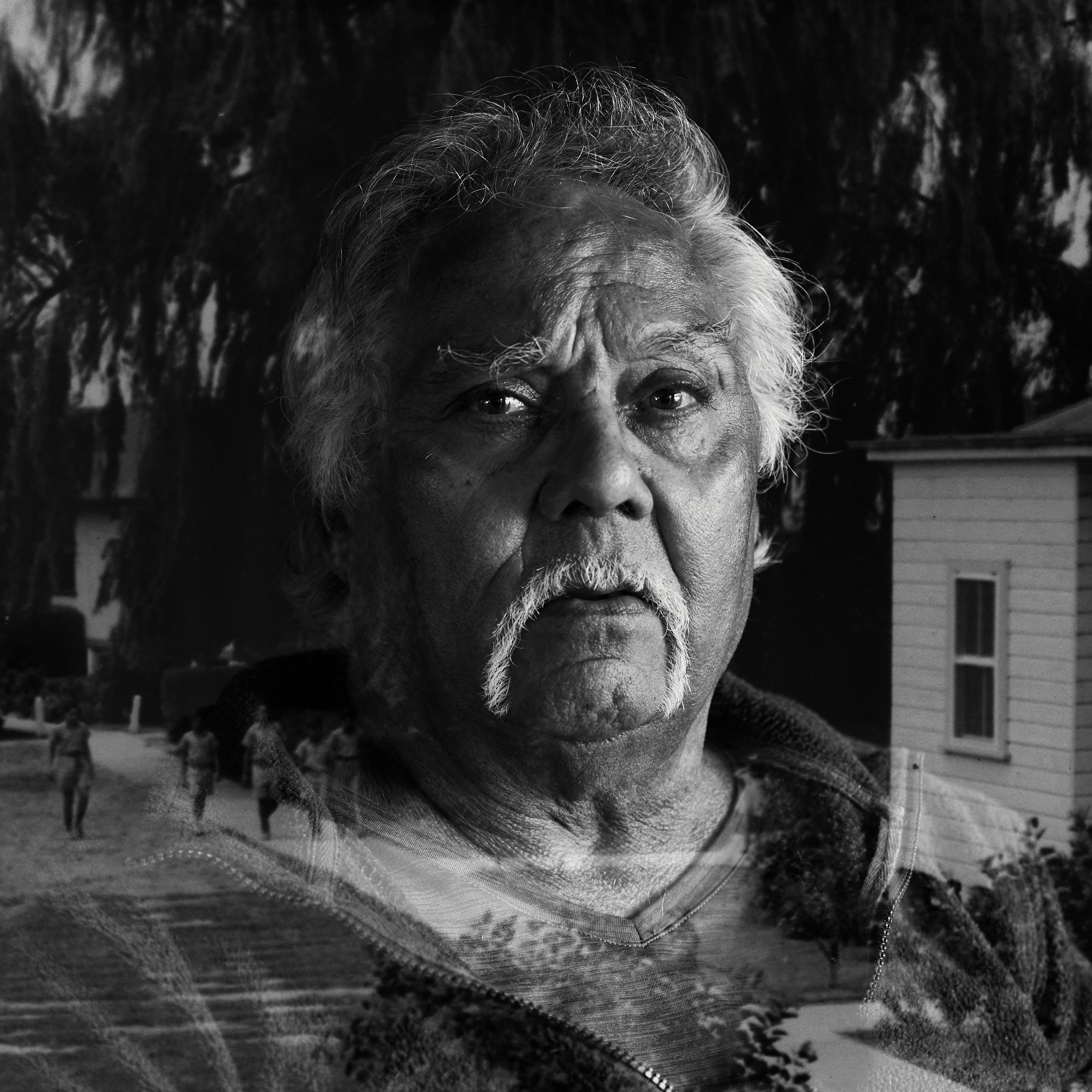 A photo of a portrait of a man overlayed with a photo of a street with a white building.