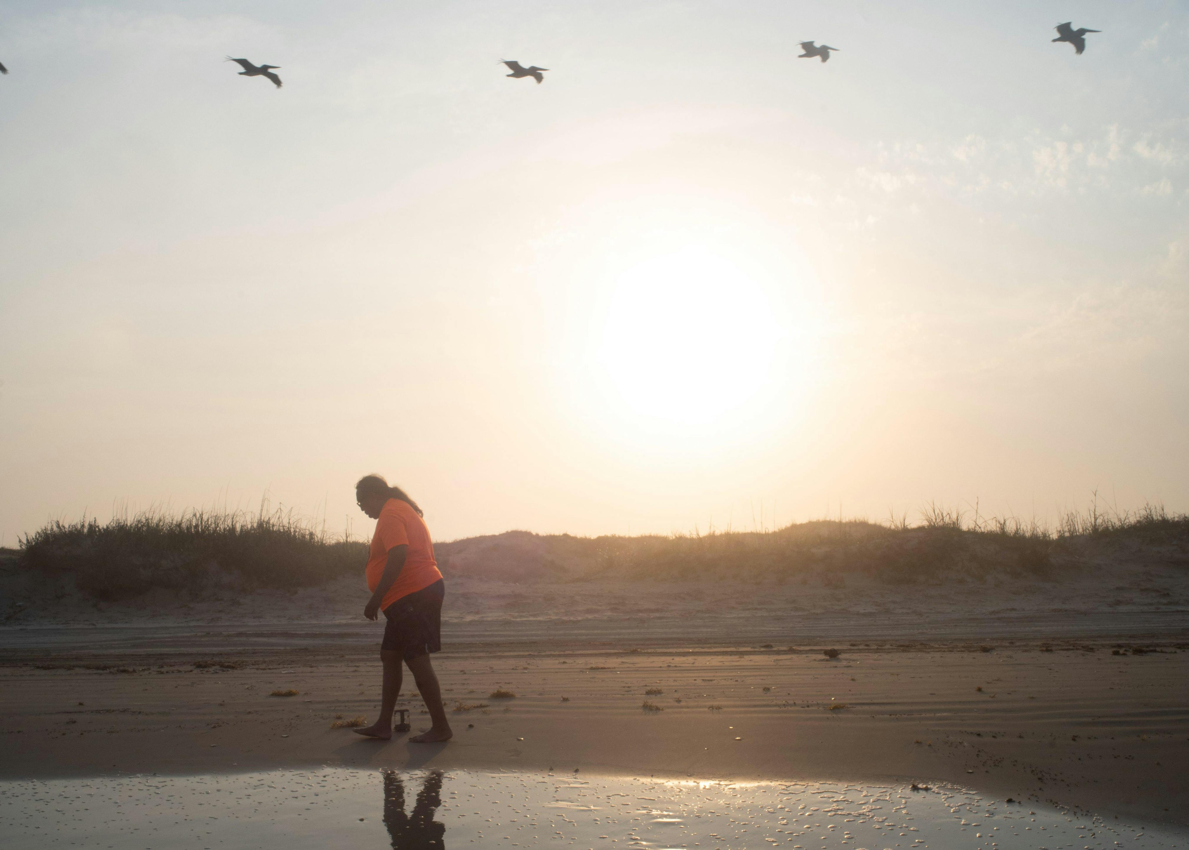 A man walking along the shore.