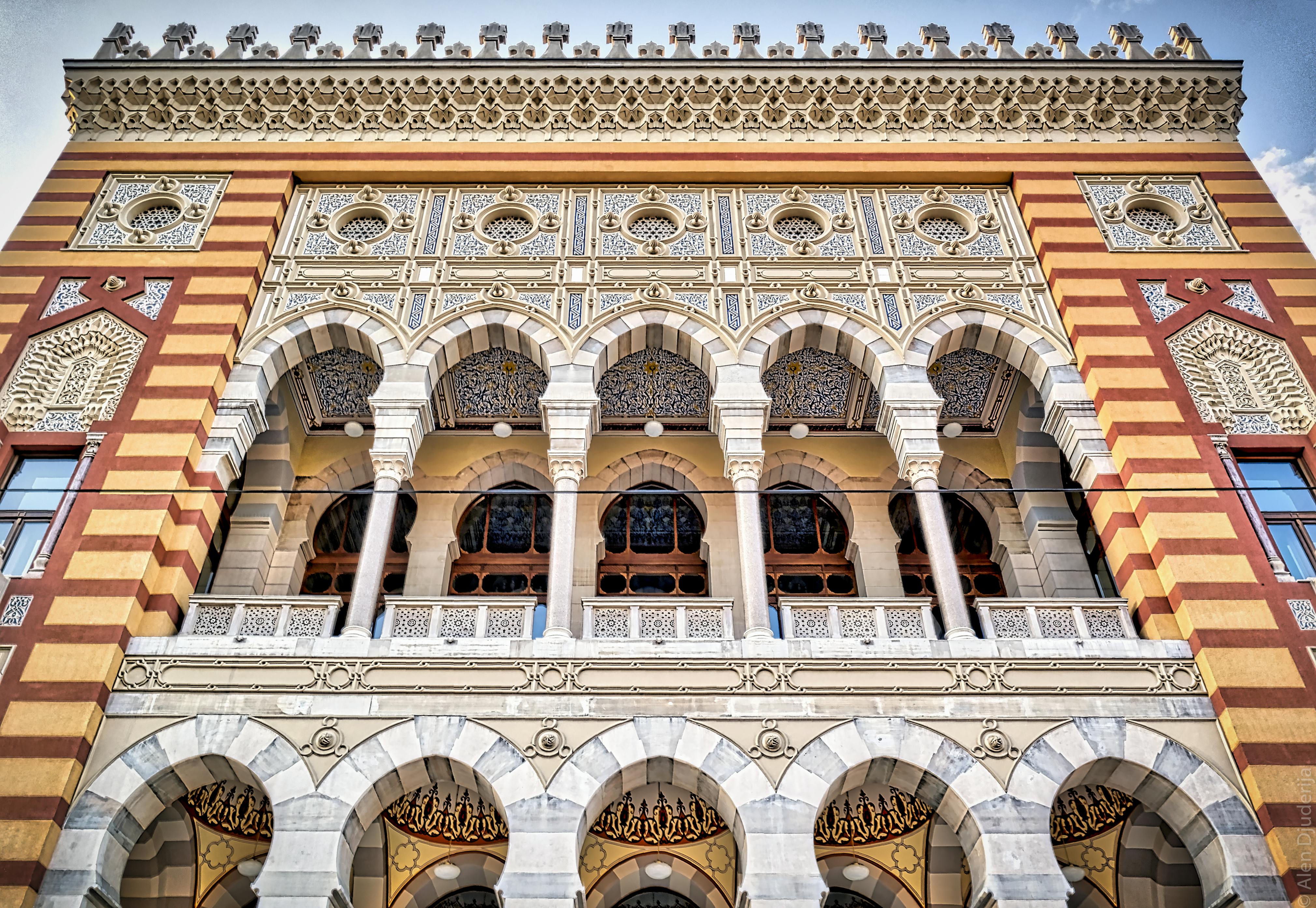 The Sarajevo City Hall (Vijećnica), a large, ornate Austro-Hungarian building with intricate architectural details.