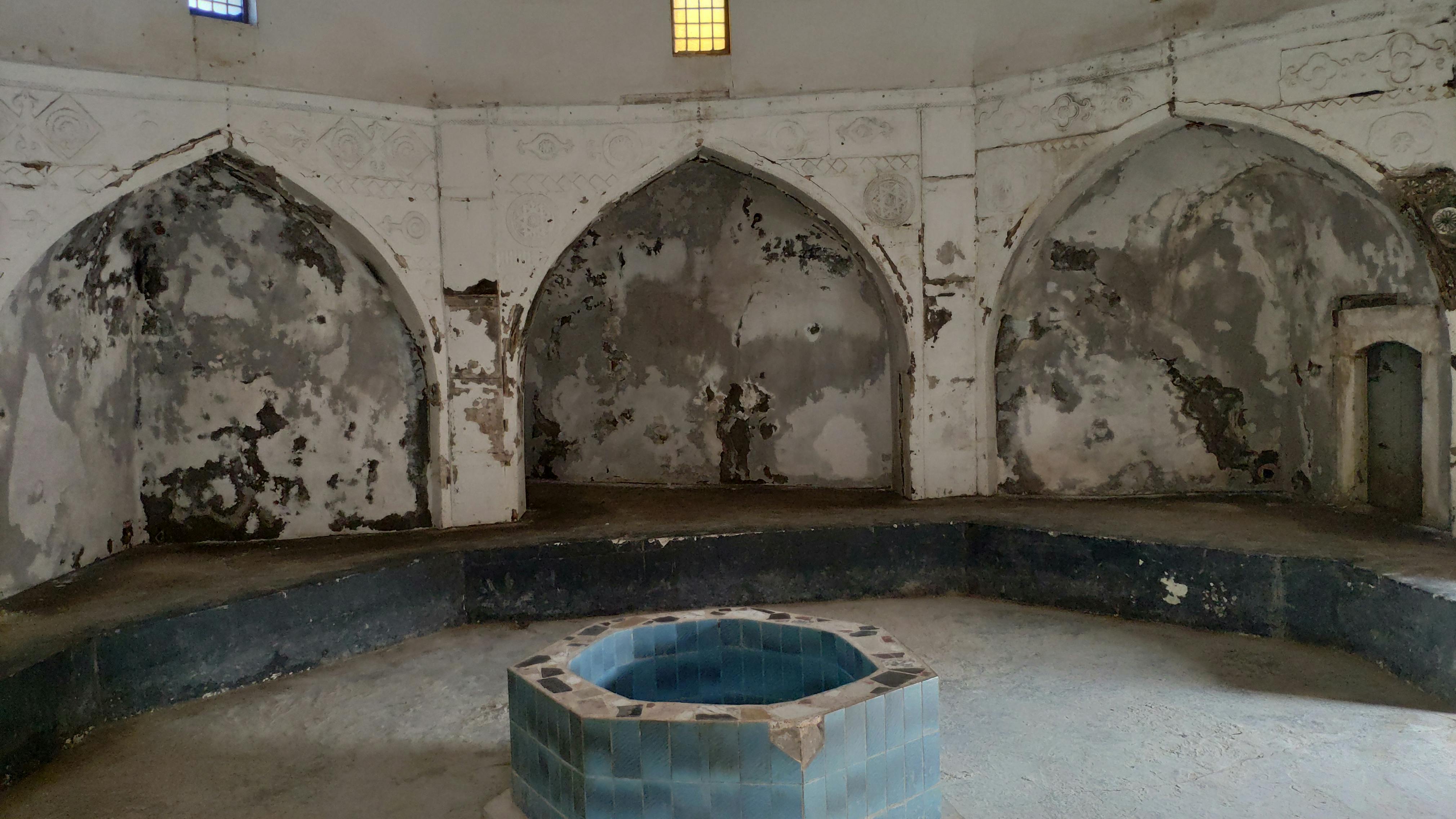 The Hammam’s outer hall, with pointed arches ornamented with carved stone works and sitting benches, 2019, photo courtesy of HCECR.